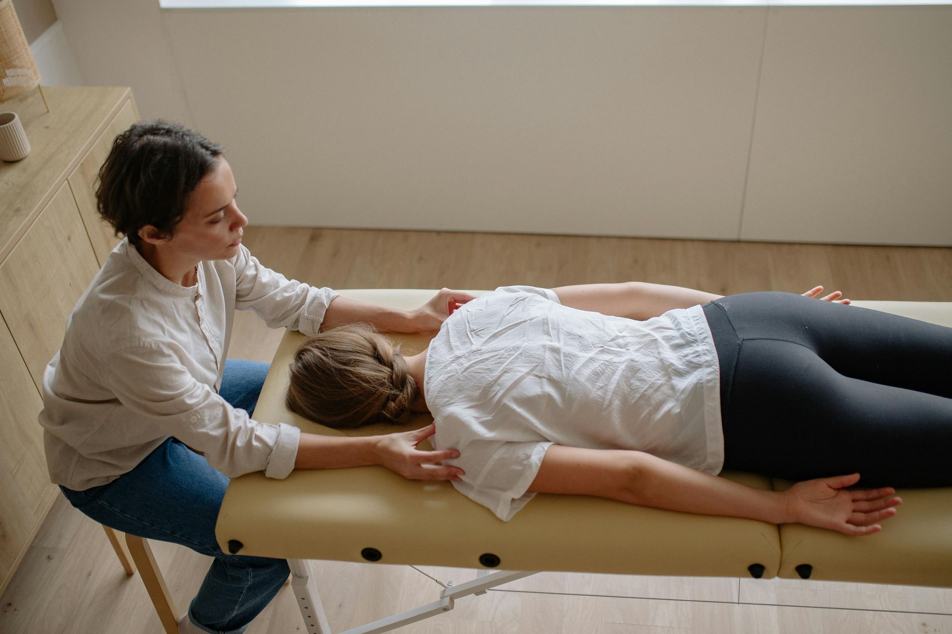 Chiropractor performing a spinal adjustment on a patient